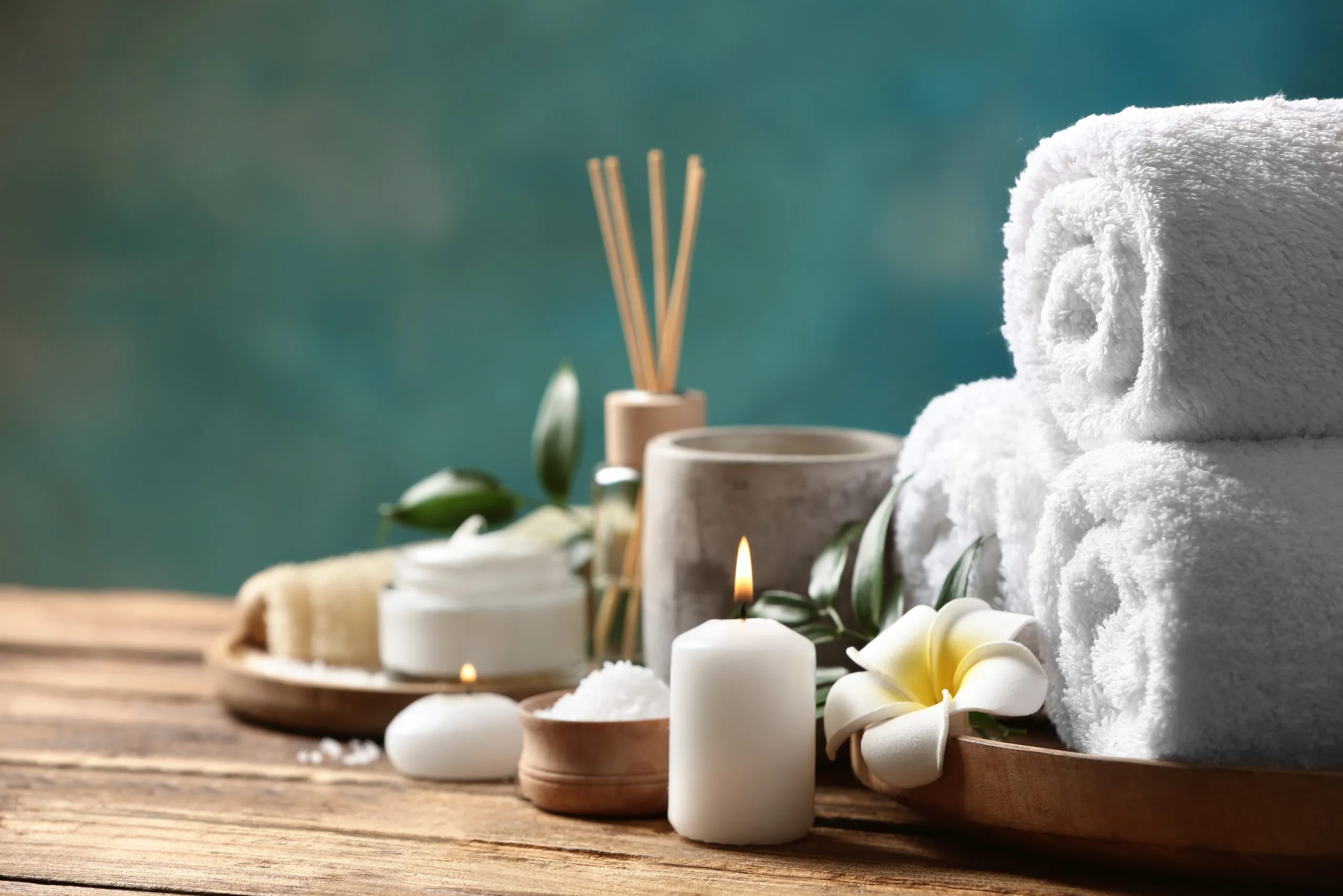 Beautiful spa composition with plumeria flower on wooden table. Space for text